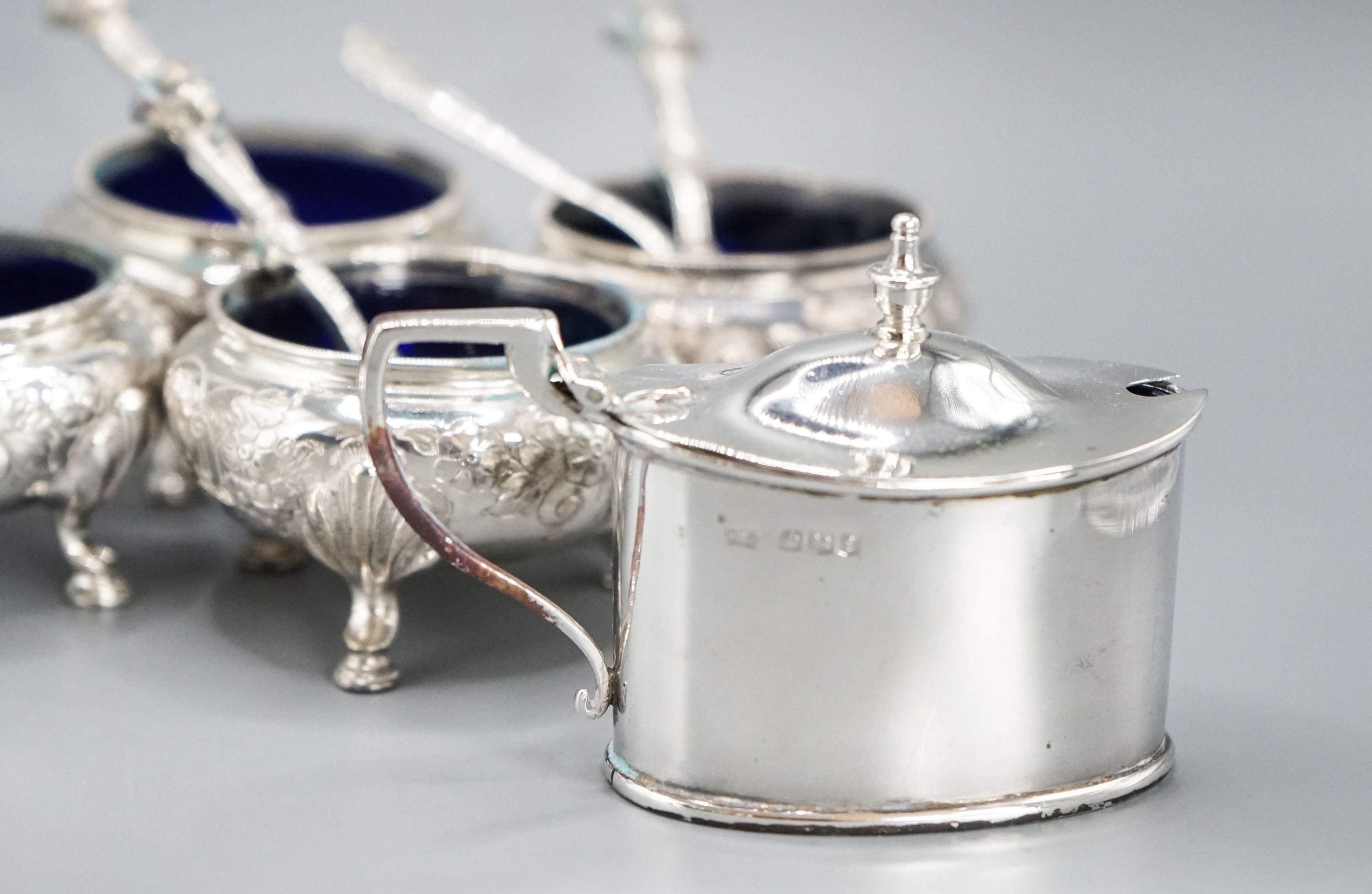 A set of four Victorian silver bun salts, Sheffield, 1869 and four associated silver spoons and a later silver mustard pot and two spoons.
